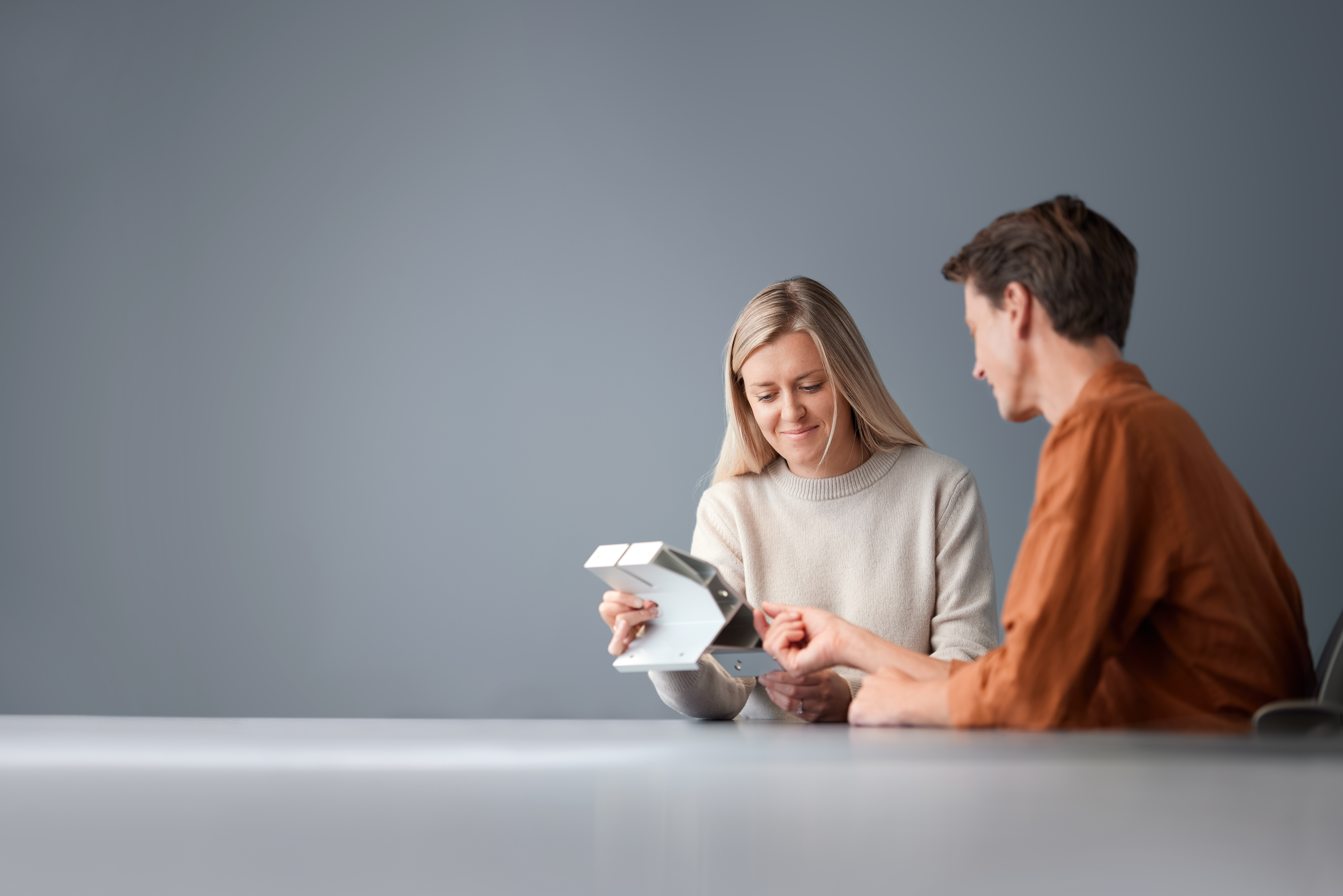 a man and woman looking at a device