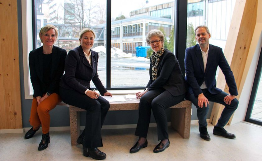 Avtalen ble signert på en helt spesiell benk som er en av verdens første betongkonstruksjoner armert med aluminium. Benken er et resultat av forskningsprosjektet DARE2C hvor både Hydro og SINTEF er involvert. Fra venstre: Nina Dahl (forskningssjef i SINTEF), Alexandra Bech Gjørv (konsernsjef i SINTEF), Hilde Merete Aasheim (Hydro-konsernsjef) og Hans Erik Vatne (Hydros teknologidirektør).