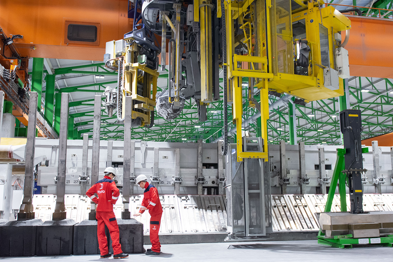 people in red suits standing in front of a large machine