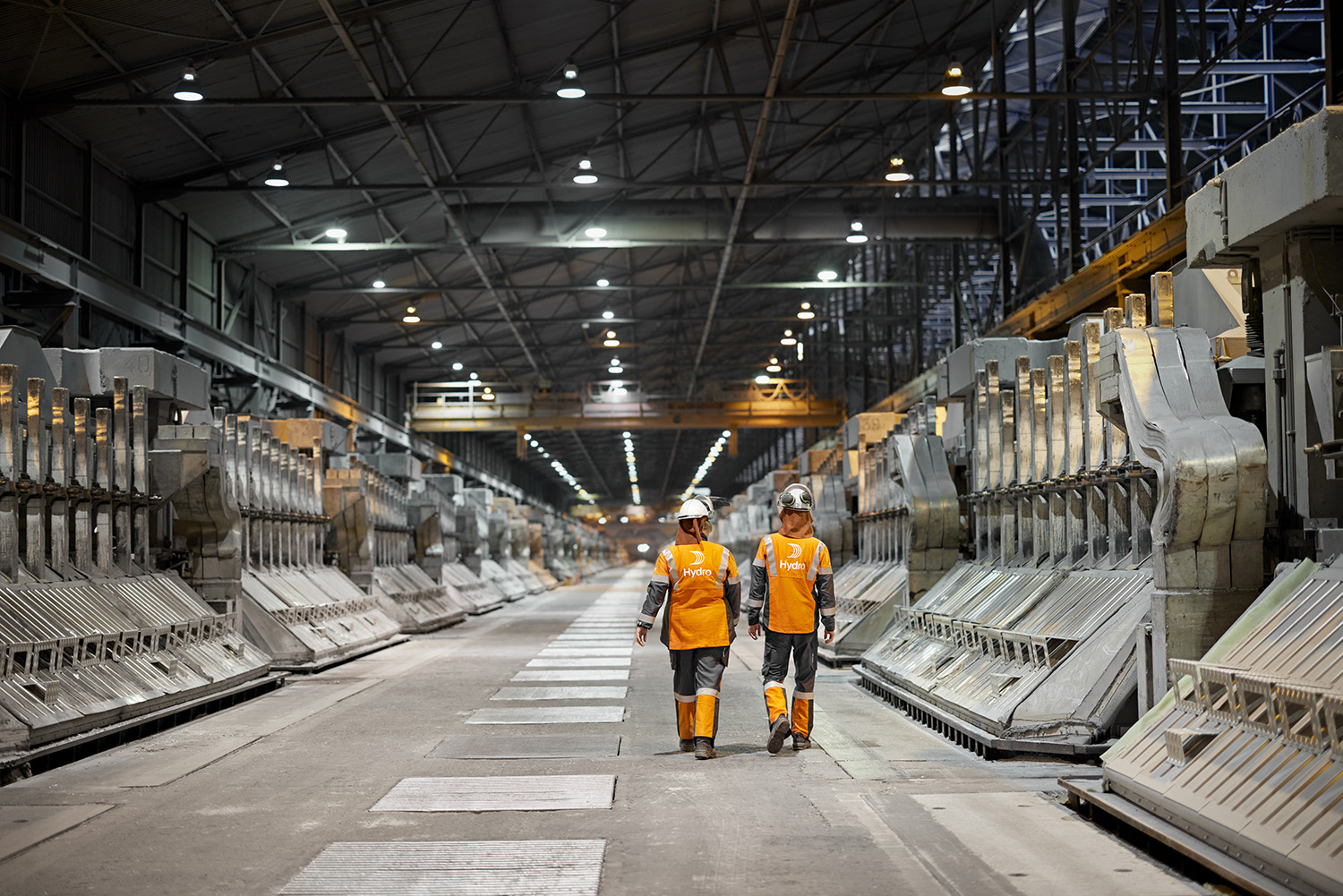 two people in safety vests in a factory