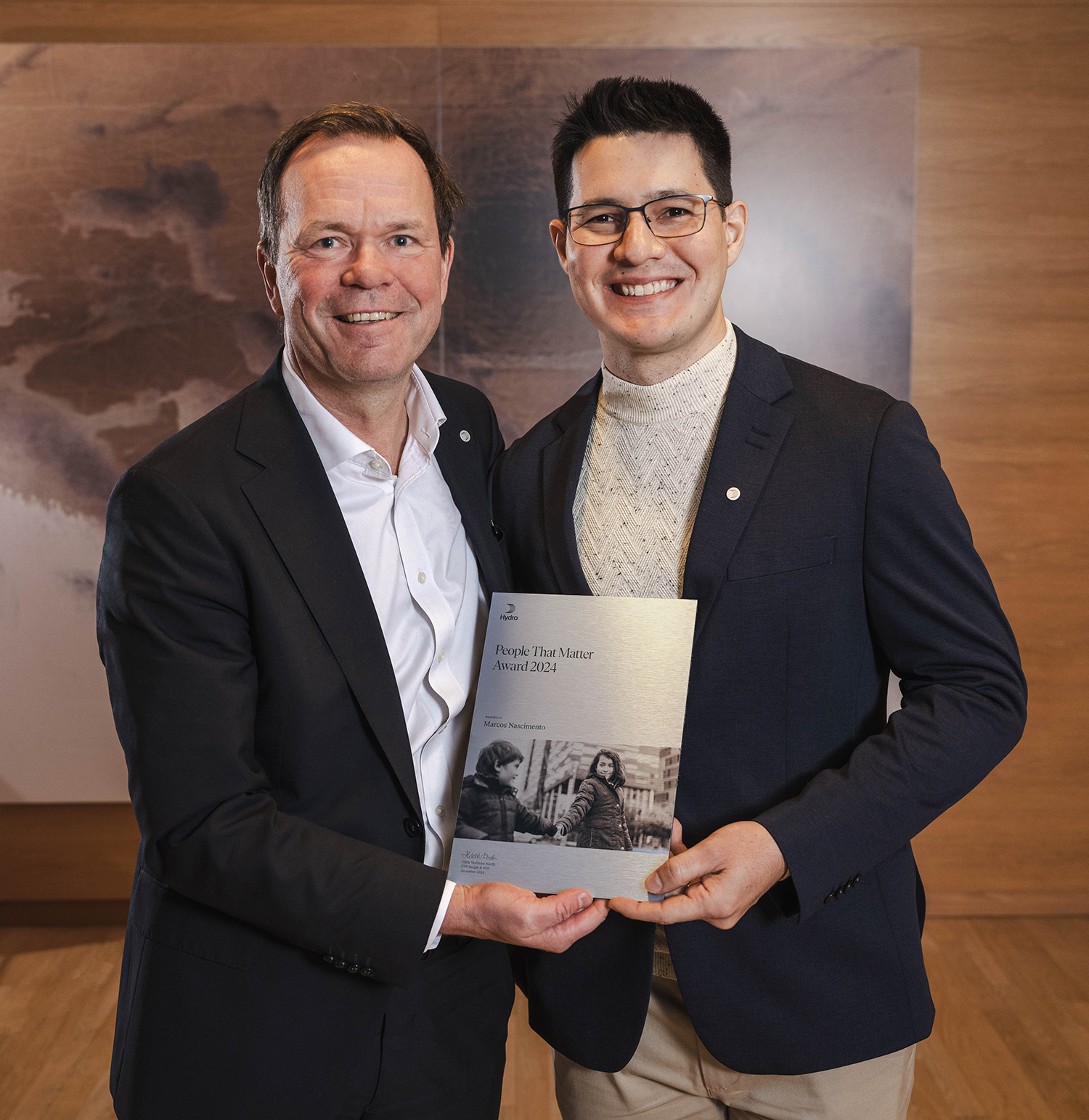 a couple of men holding a plaque