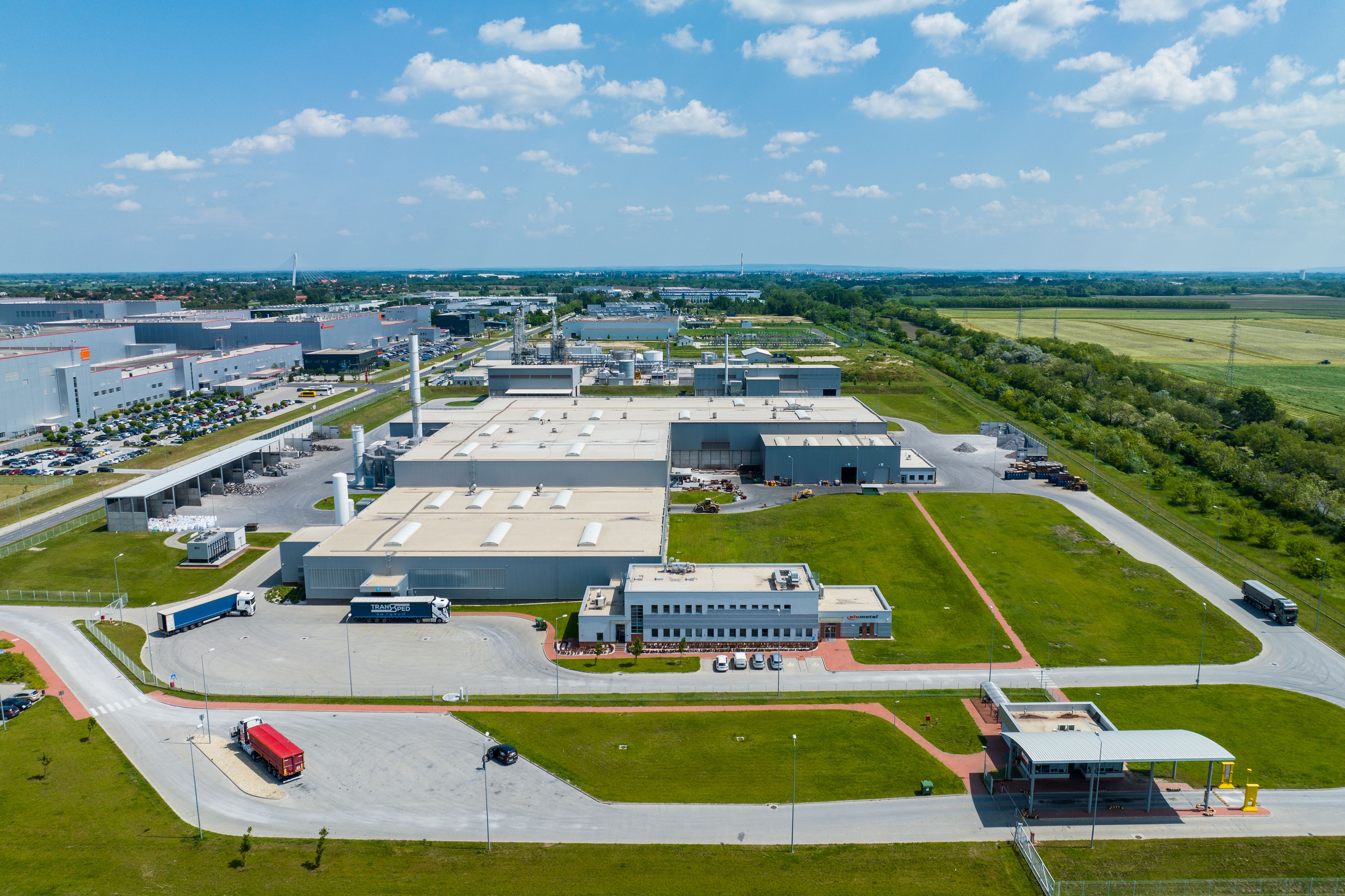 a large factorywith a green lawn and a road